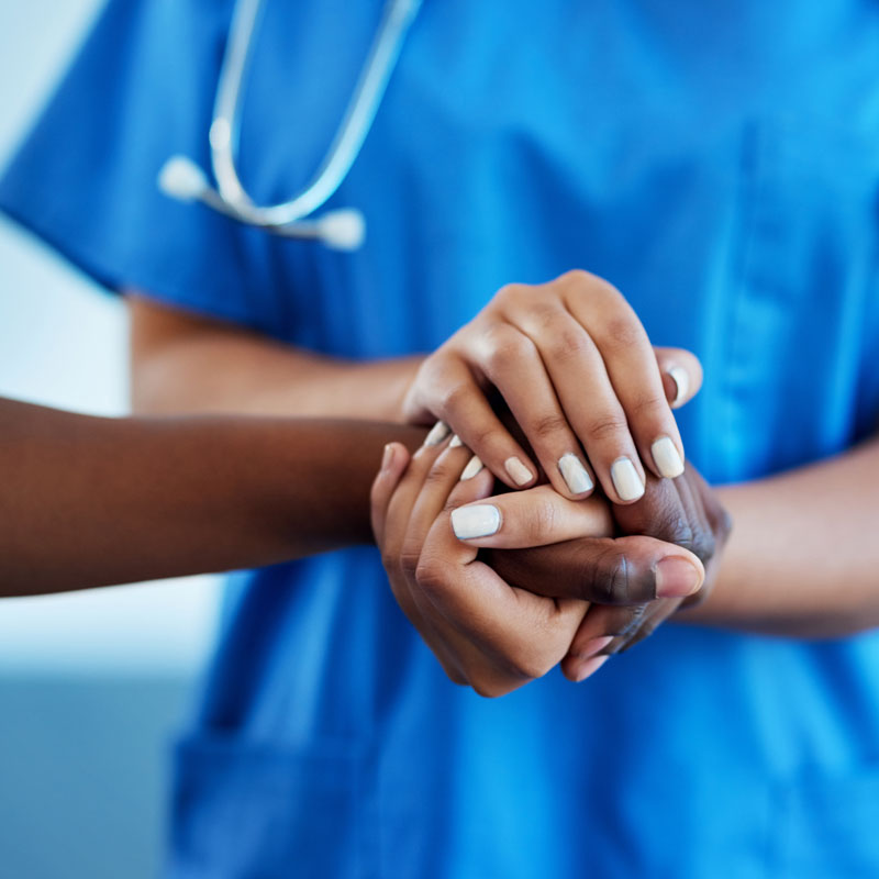 nurse holding patient's hand