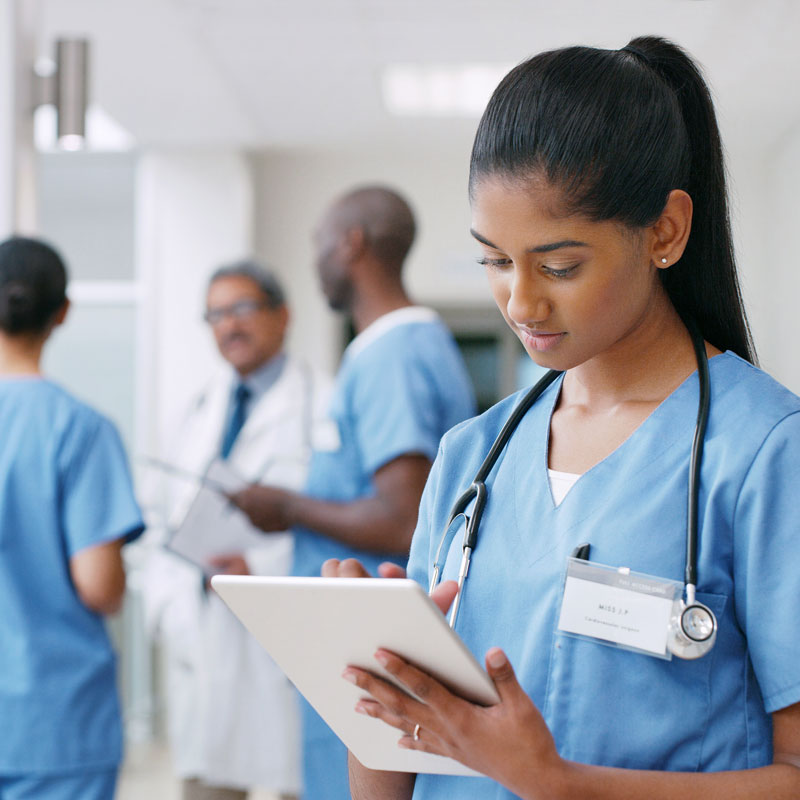 nurse working on tablet near other physicians